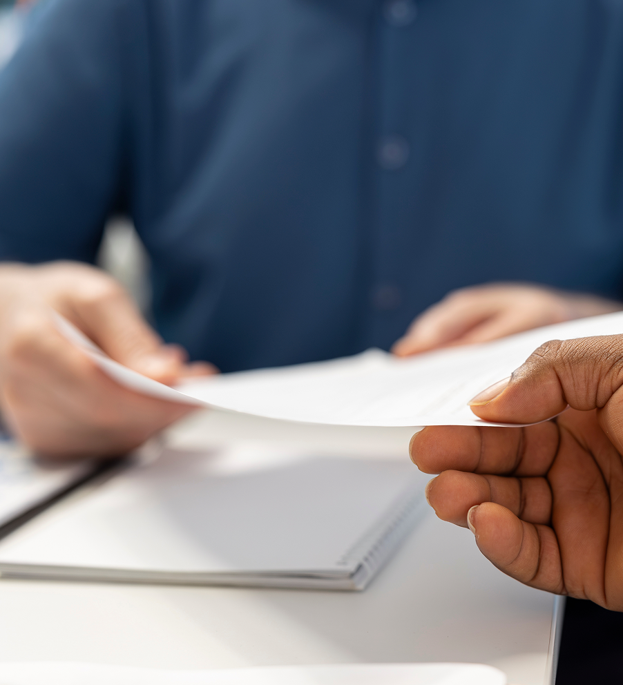 Paperwork being handed between 2 people