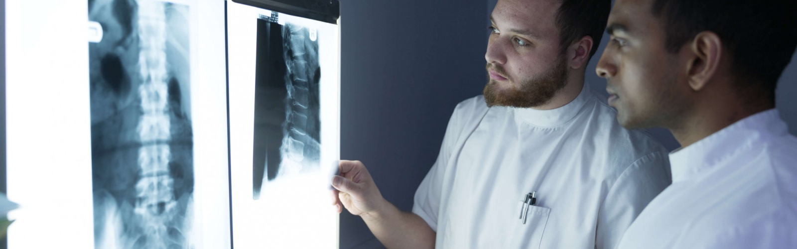 A pair of chiropractors looking at an x-ray