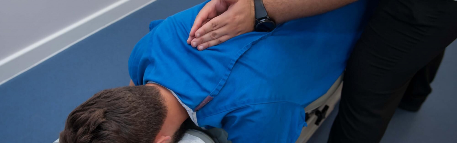 A male chiropractor treating a male patients back