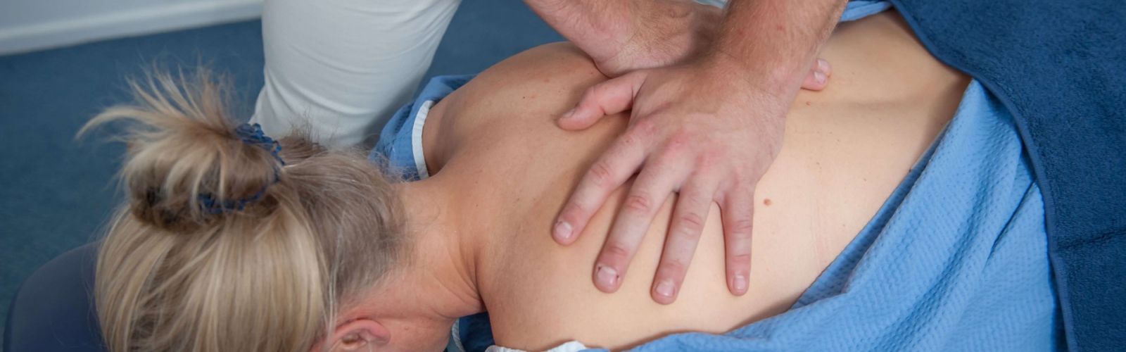 A chiropractor giving treatment on a patients back lying face down