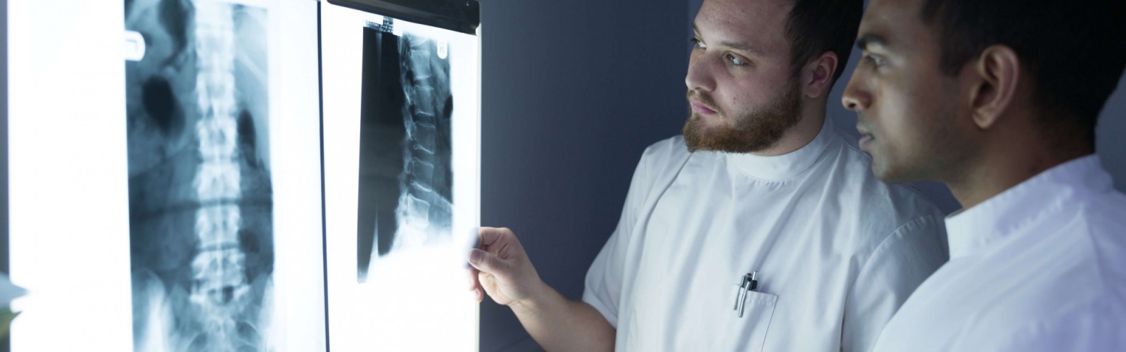 A pair of chiropractors looking at an x-ray